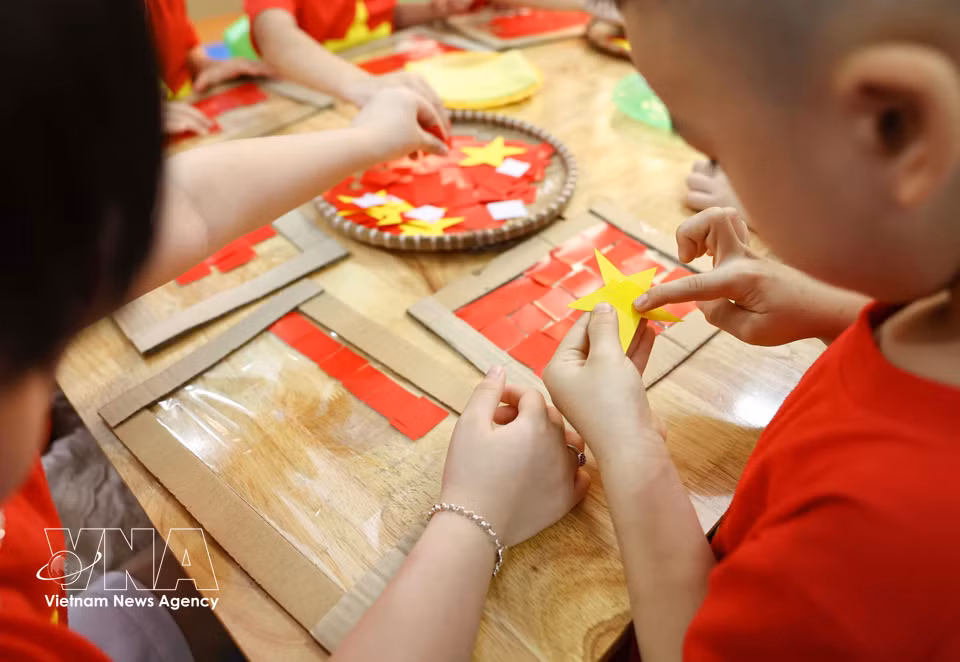 With care and attention, the children craft vivid and meaningful representations of the national flag. (Photo: VNA)