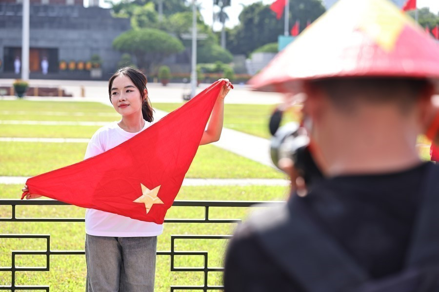 The red flag with a yellow star is an indispensable prop in these festive photographs. (Photos: VNA)