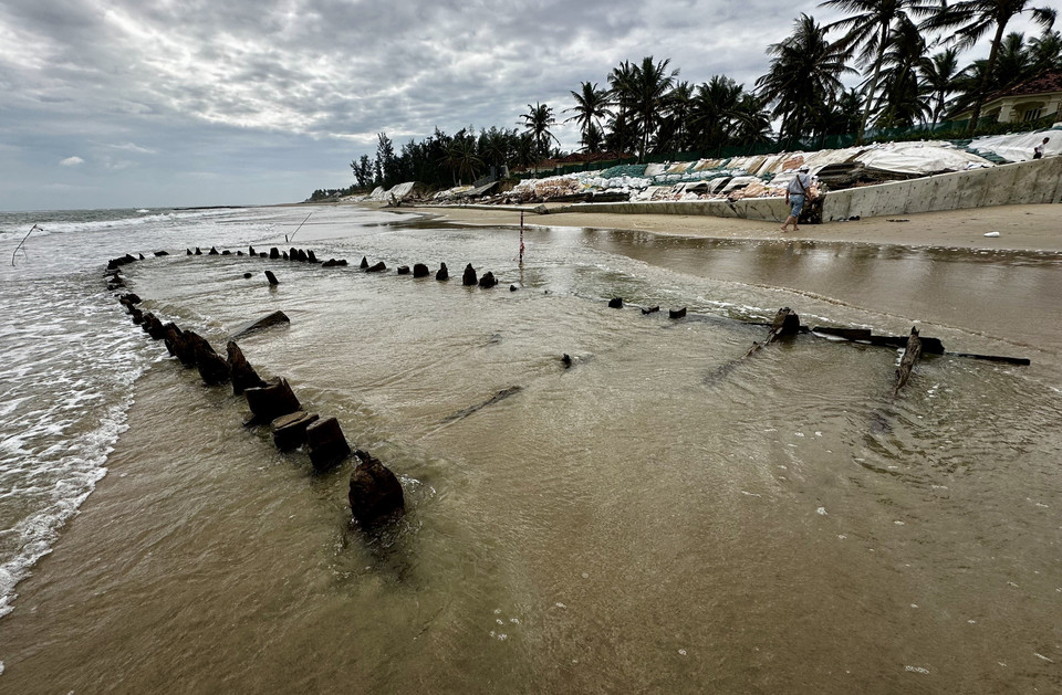 The wooden structure appears and disappears among waves and sand. (Photo: VNA)