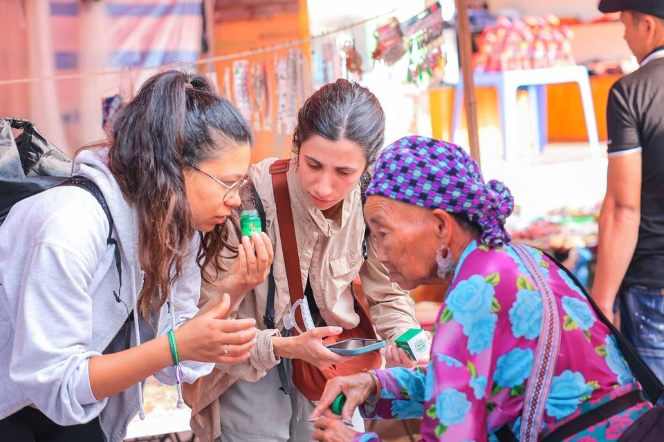 Foreign visitors explore goods at a local market in Bac Ha plateau. (Photo: VNA)