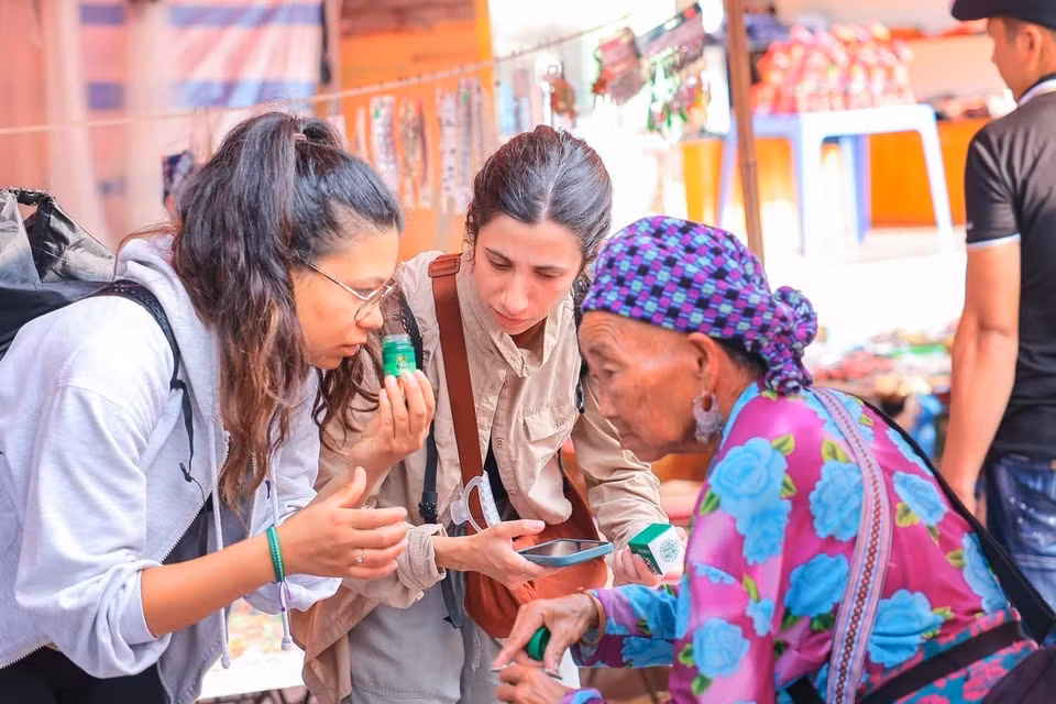Foreign visitors explore goods at a local market in Bac Ha plateau. (Photo: VNA)