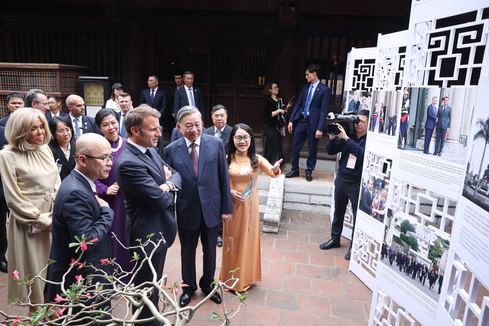 Party General Secretary To Lam and his spouse, together with French President Emmanuel Macron and his spouse, visit a photo exhibition on Vietnam–France relations by the Vietnam News Agency, held within the grounds of the Temple of Literature. (Photo: VNA)