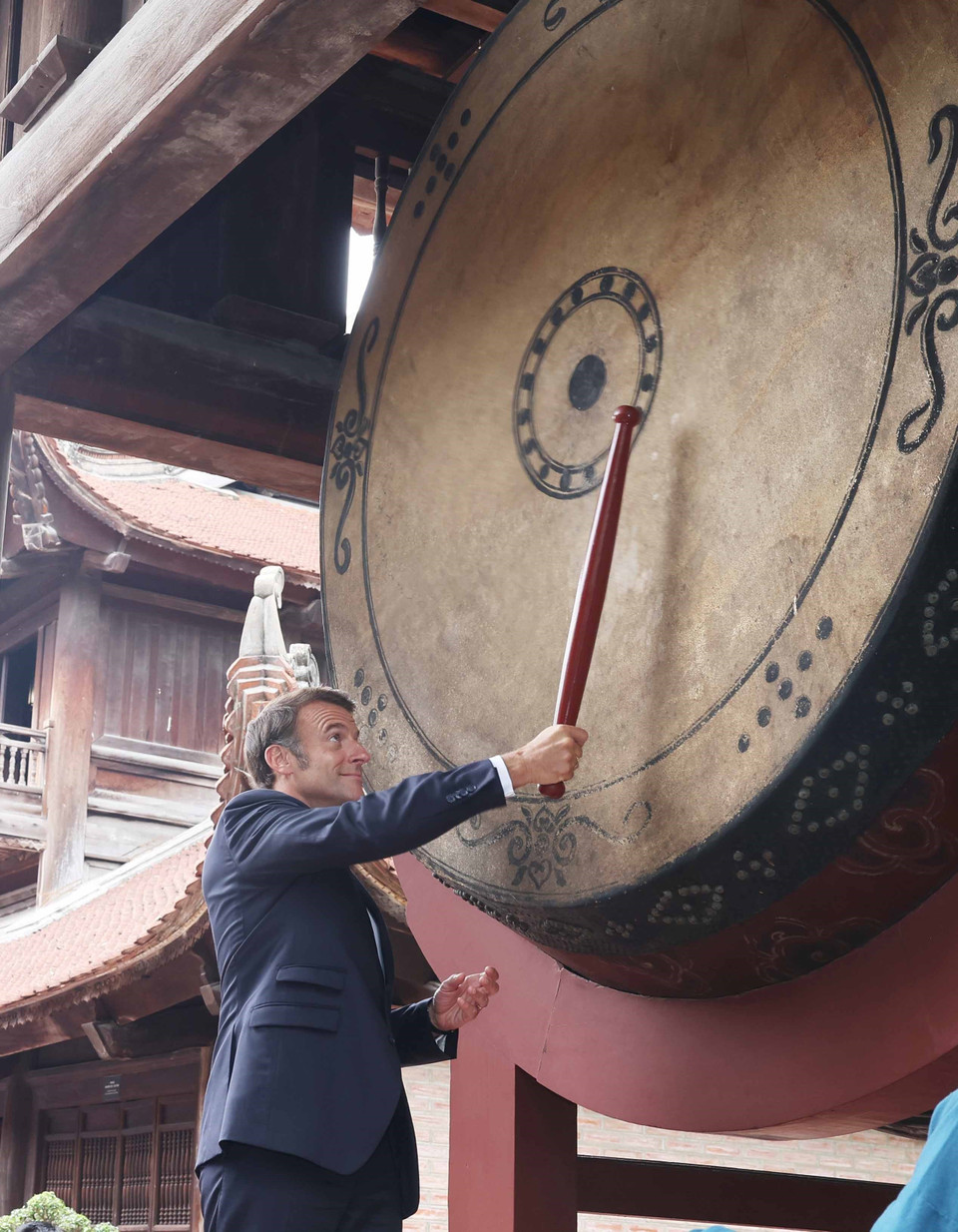 French President Emmanuel Macron beats the ceremonial thunder drum at the Thai Hoc section of the Temple of Literature. (Photo: VNA)