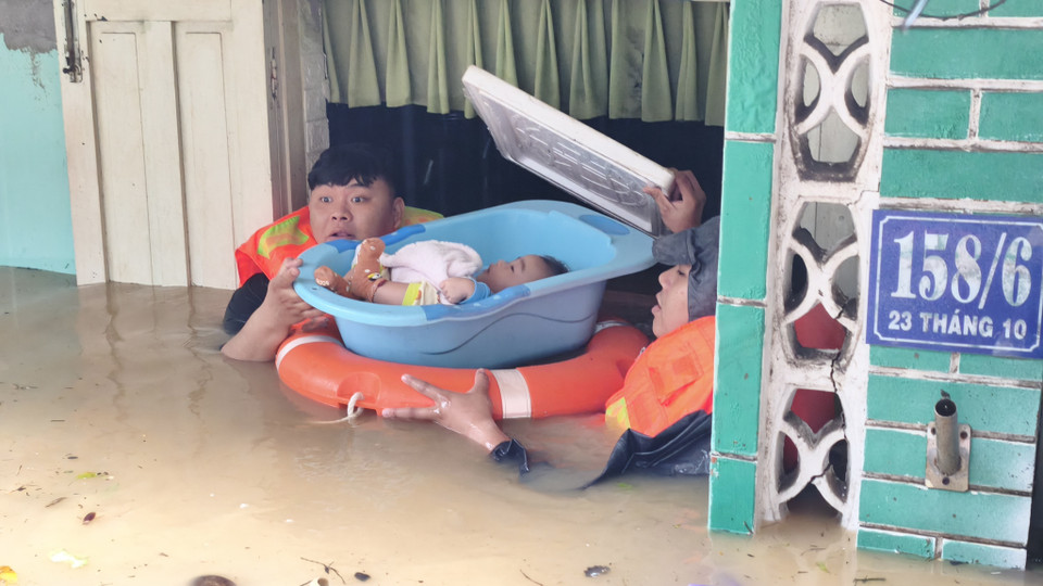 Authorities assist a child to safety from a house heavily flooded in Tay Nha Trang ward, Khanh Hoa. (Photo: VNA)