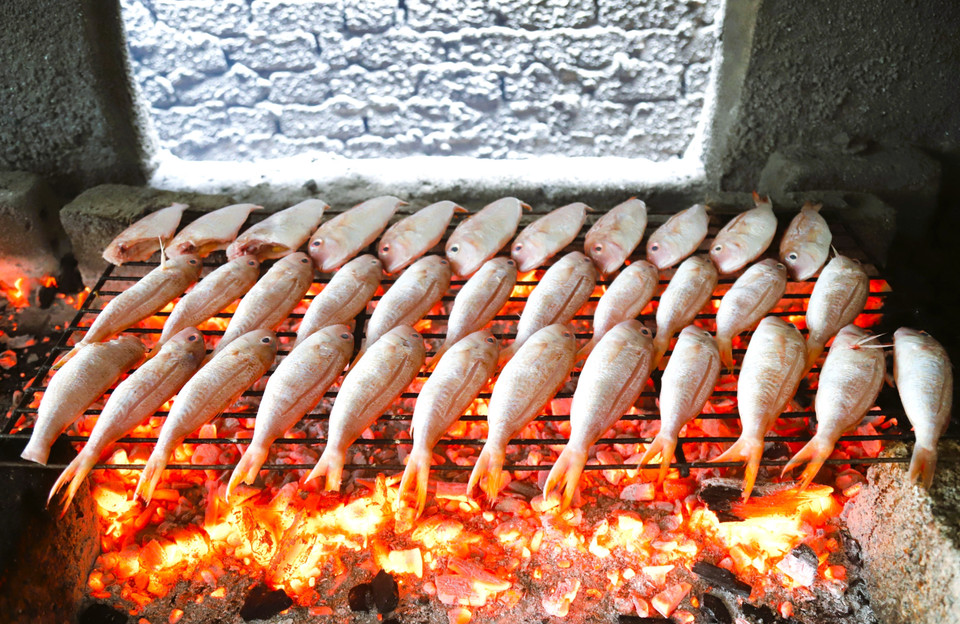 Luong fish are arranged on metal racks welded from thin iron rods and grilled directly over glowing charcoal. (Photo: VNA)