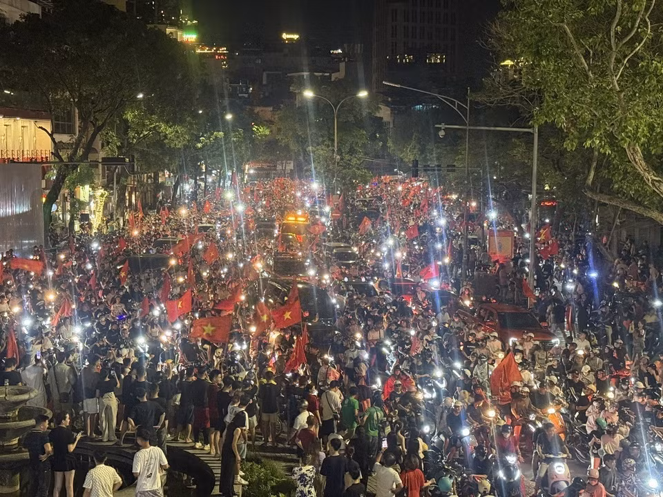 Locals parade with national flags through Hanoi streets. (Photo: VNA)