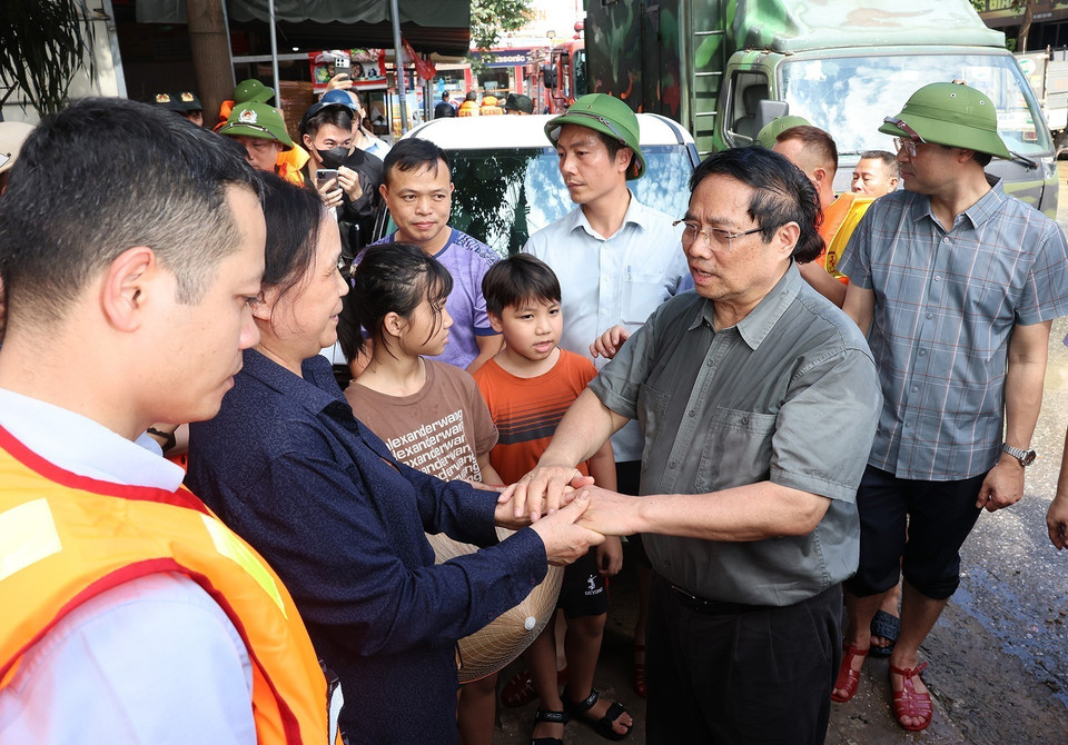 Prime Minister Pham Minh Chinh visits and encourages residents affected by flooding in Phan Dinh Phung ward, Thai Nguyen province. (Photo: VNA)