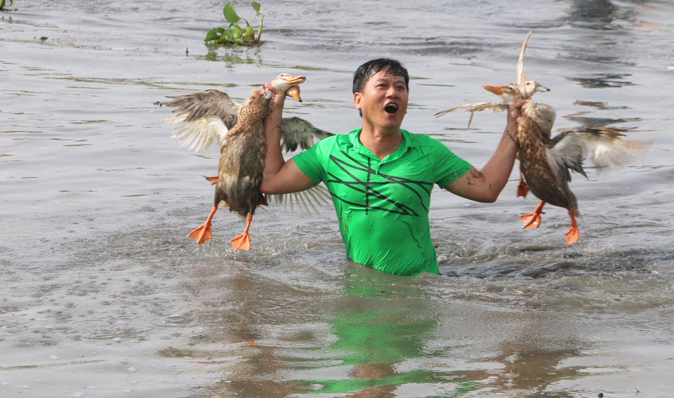 Participants show excitement with their catch after joining the traditional duck-catching game. (Photo: VNA)