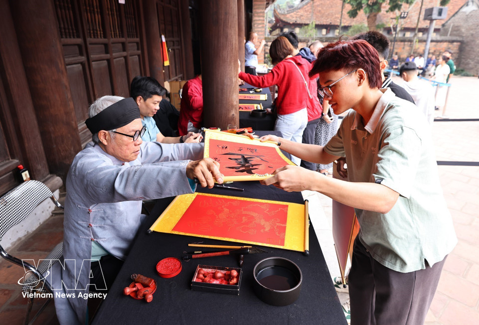 Hanoi people visit Van Mieu - Quoc Tu Giam (The Temple of Literature) to ask for calligraphy with hope of attaining wisdom, peace and luck for the new year. (Photo: VNA)