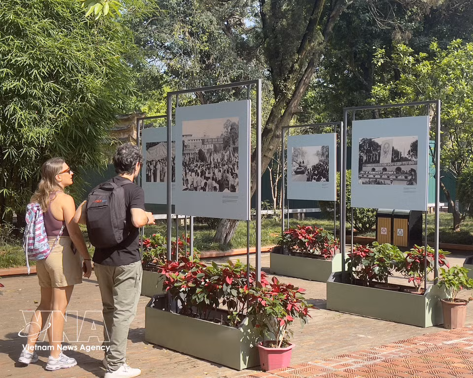 International tourists visit the photo exhibition “Echoes of a New Day” at the Thang Long Imperial Citadel. (Photos: VNA)