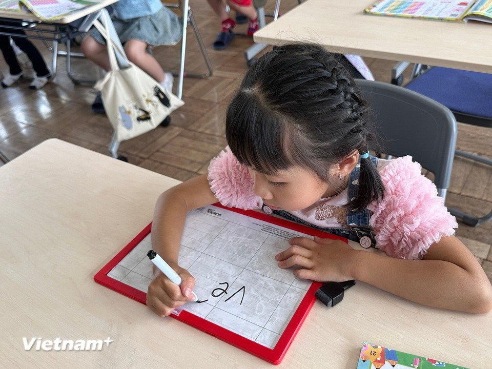 A female student writes the word “ve so” (lottery ticket) on the board. (Photo: VietnamPlus)