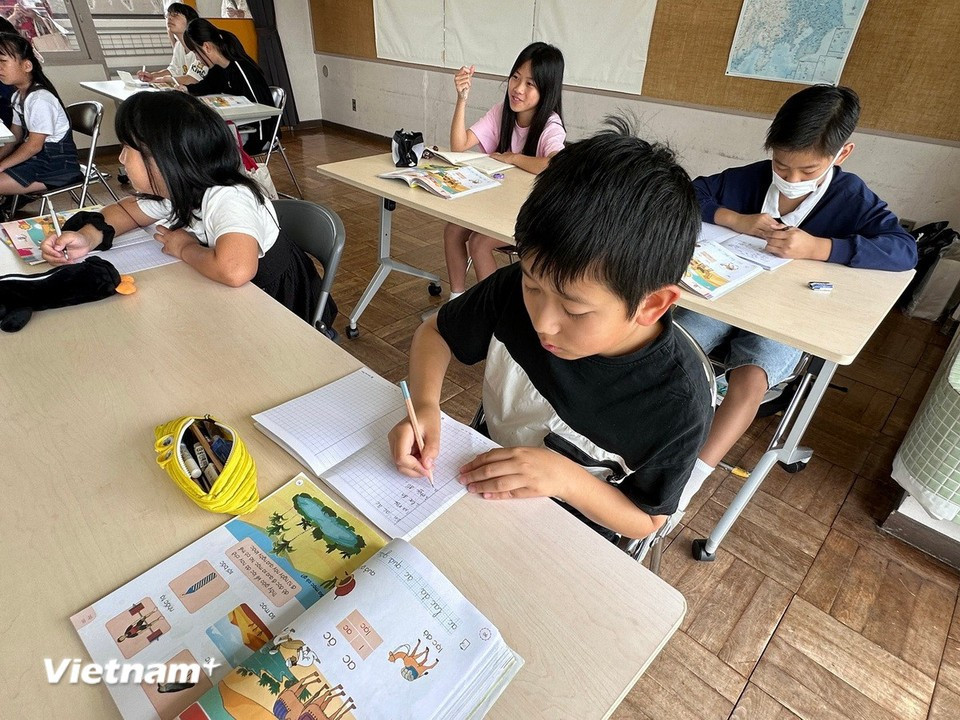A first-grade female student eagerly steps up to the board to write “he ve” (summer returns). (Photo: VietnamPlus)