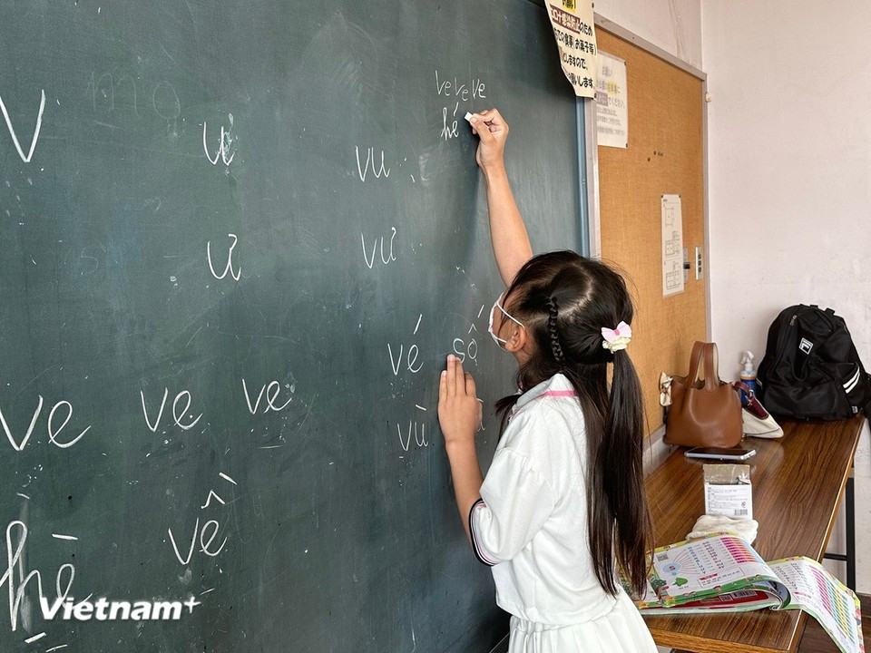 Vietnamese children confidently take turns practicing writing on the board. (Photo: VietnamPlus)