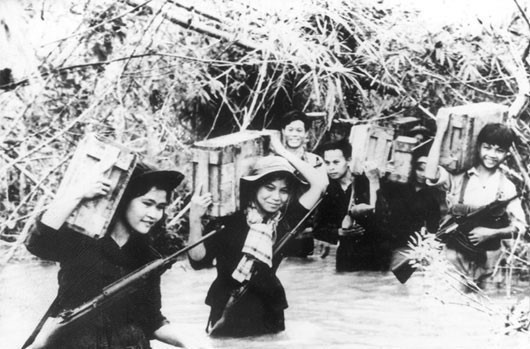 In the resistance war against the US, the VPA braved hardships and sacrifice on the southern battlefield, fighting tirelessly against enemy troops while protecting revolutionary bases, building militia forces, and supporting people to rise up to claim their freedom. In the photo: Militia transport ammunition for the revolutionary forces during the resistance war against the US. (Photo: VNA archives)