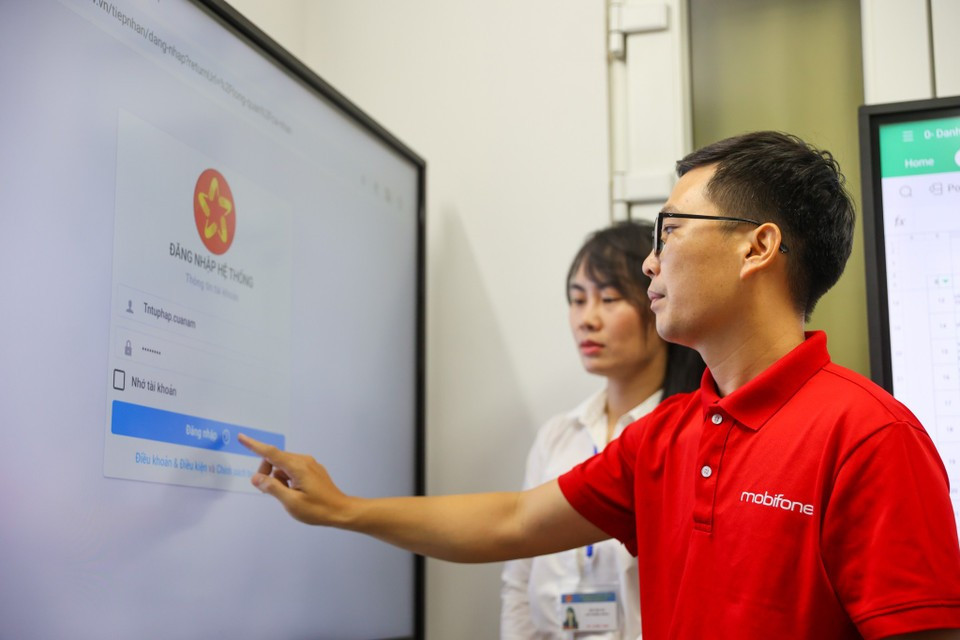 A MobiFone employee assists citizens with technology under the new e-administration solution. (Photo: VietnamPlus)
