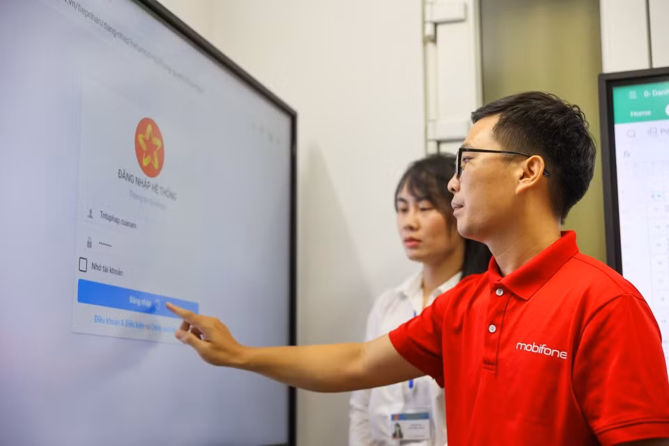 A MobiFone employee assists citizens with technology under the new e-administration solution. (Photo: VietnamPlus)