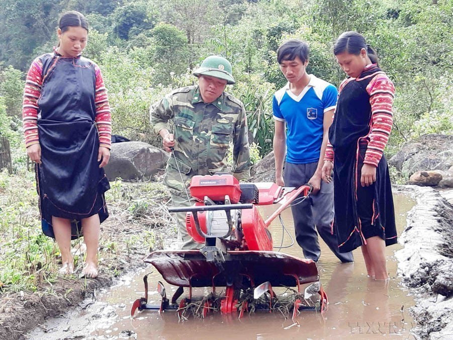 Officers and soldiers of the Lai Chau Border Guard guide local residents in using plowing machines for wet rice cultivation, resulting in higher economic efficiency. (Photo: VNA)