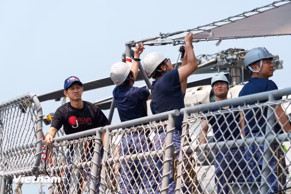 Crew members work together to install sunshades on the deck in preparation for reception and exchange activities. (Photo: VietnamPlus)