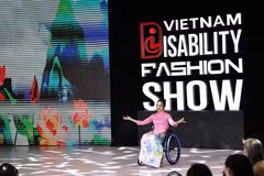 A model with physical challenge confidently showcase ao dai (Vietnamese traditional long dress) on the fashion runway. (Photo: VNA)