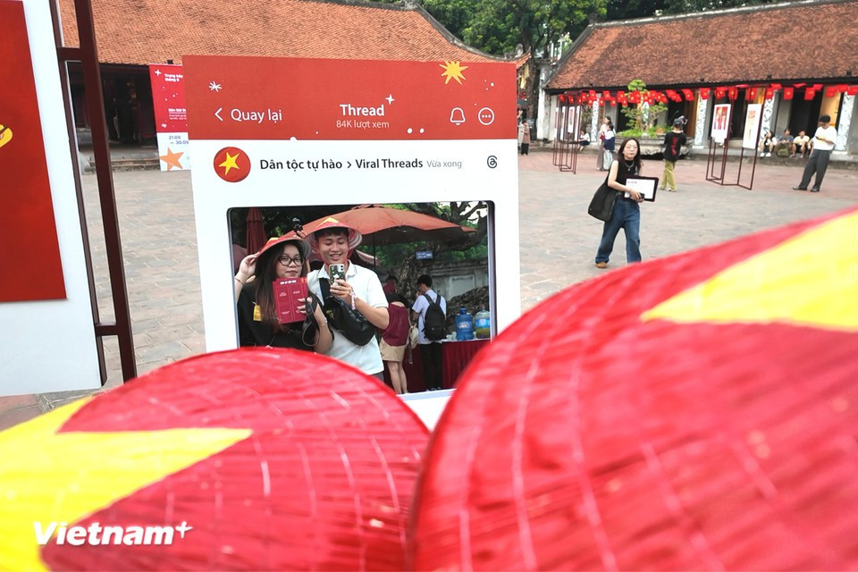 Beyond the gallery walls, visitors engage in photo check-ins, expressing their patriotism in a creative way. (Photo: VietnamPlus)