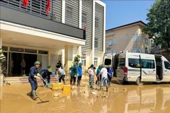 Volunteers clean up mud and debris after the flood at the headquarters of the Thai Nguyen Department of Health. (Photo: VNA)