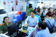 A police officer at the Immigration Division of southern Dong Nai province is instructing foreigners how to register for a level-2 electronic identification account. (Photo: VNA)