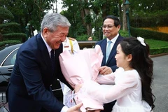 Kyrgyz PM Adylbek Kasimalyev receives flowers from a Hanoi kid at the welcome ceremony on March 6. (Photo: VNA)