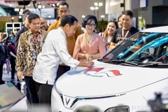 Indonesian President Joko Widodo signs on a VinFast car during the launch event of the Vietnamese automaker’s right-hand drive EVs in the market on February 15, 2024. (Photo: VNA)