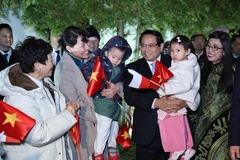 Prime Minister Pham Minh Chinh and his spouse meet with the staff of the Vietnamese Embassy and representatives of the Vietnamese community in Poland on January 16 evening (local time). (Photo: VNA)