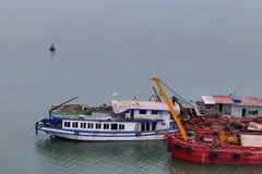 The Vinh Xanh 58 tourist boat is towed ashore on July 20 morning. (Photo: VNA)