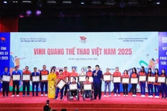 Athletes and coaches receives their certificates and awards for their remarkable achievement in the past year at the Vietnam Sport Glory Day in Hanoi on March 22. (Photo: VNA)