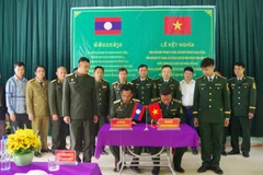 Representatives of the Pa Thom border guard station of Dien Bien province and Border Guard Company 119 of Laos’ Phongsaly province sign the document on the twinning relationship on May 26. (Photo: VNA)