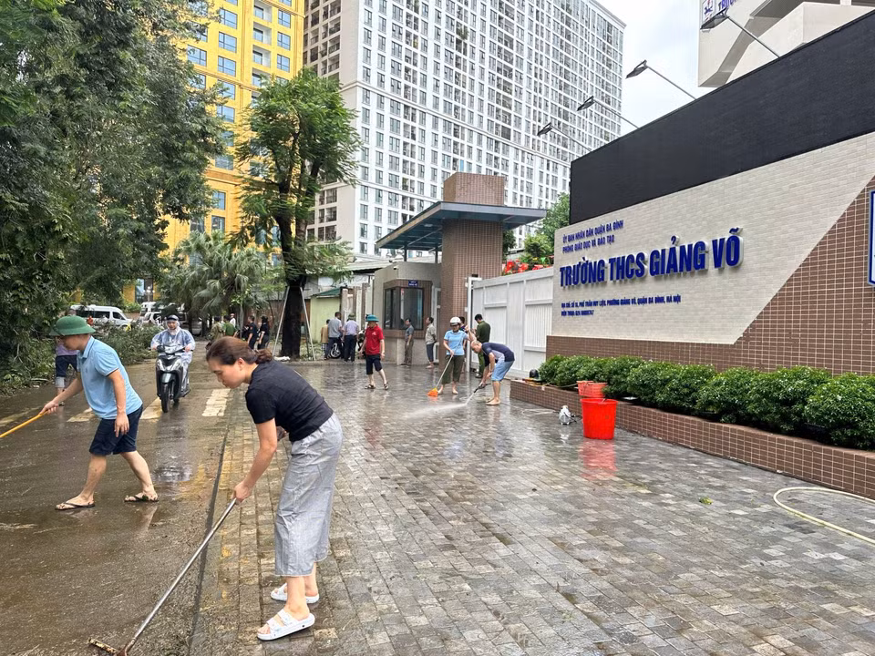 Staff and teachers of Giang Vo Secondary School (Ba Dinh district, Hanoi) clean the area in front of the school. (Photo: Tin Tuc newspaper)