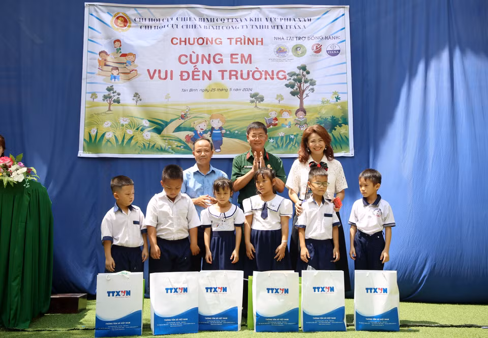 Tran Trang Duong, Chairman of the Vietnam News Agency War Veterans Association (centre), and Director of the Yamamoto-Huynh Import-Export Trading Co., Ltd., Huynh Thi Mong Tuyen (right), present gifts to school leaders and students. (Photo: VNA)