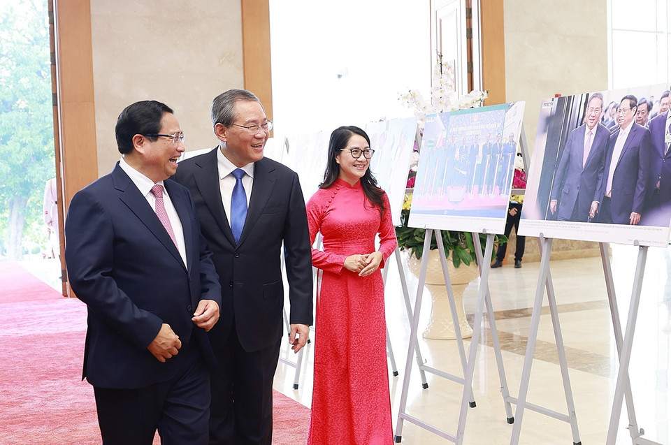 Prime Minister Pham Minh Chinh and Premier Li Qiang view a photo exhibition on Vietnam-China cooperation, organised by the Vietnam News Agency, just before their talks. (Photo: VNA)