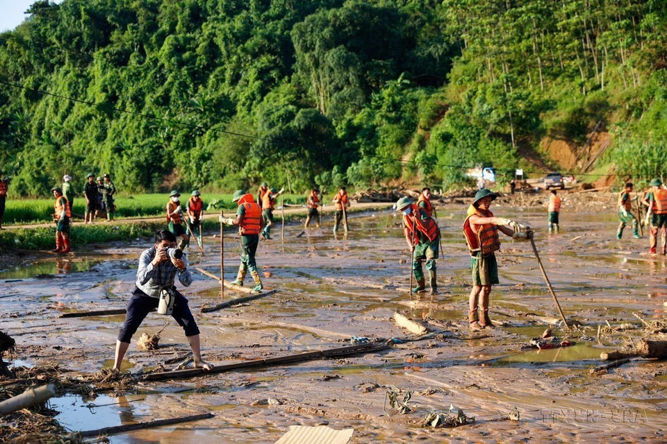 VNA photographer Duong Giang covers news at landslide-hit Lang Nu village, Phuc Khanh commune, Bao Yen district, Lao Cai province, on September 12. (Photo: VNA)