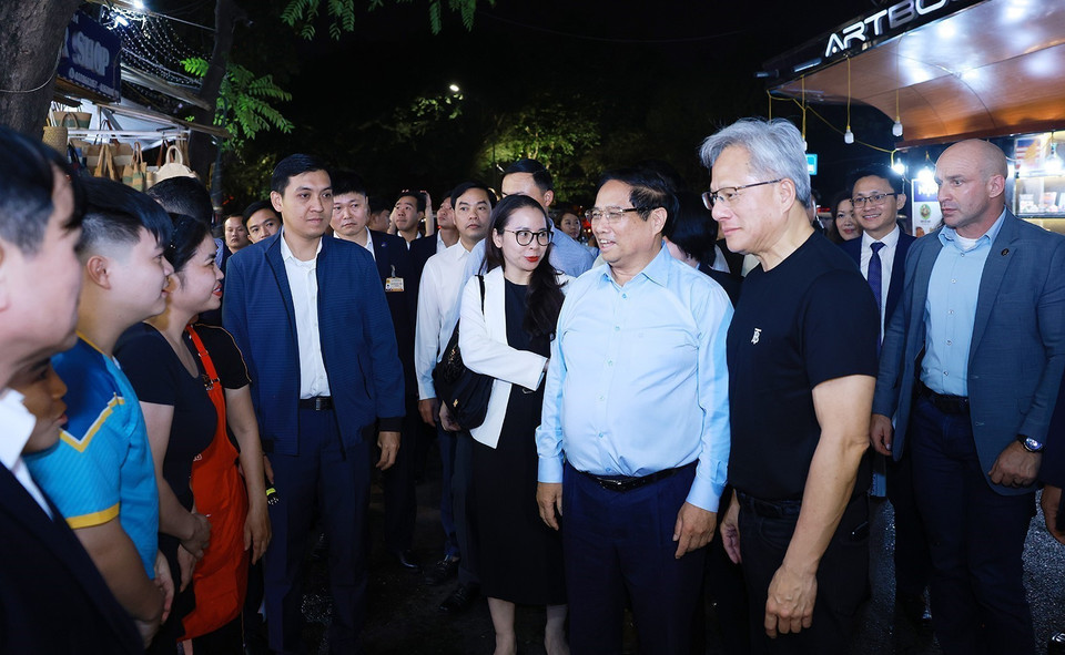 Prime Minister Pham Minh Chinh and President and CEO of NVIDIA Jensen Huang visit Hanoi's Old Quarter and meet with the residents. Photo: Duong Giang - VNA.