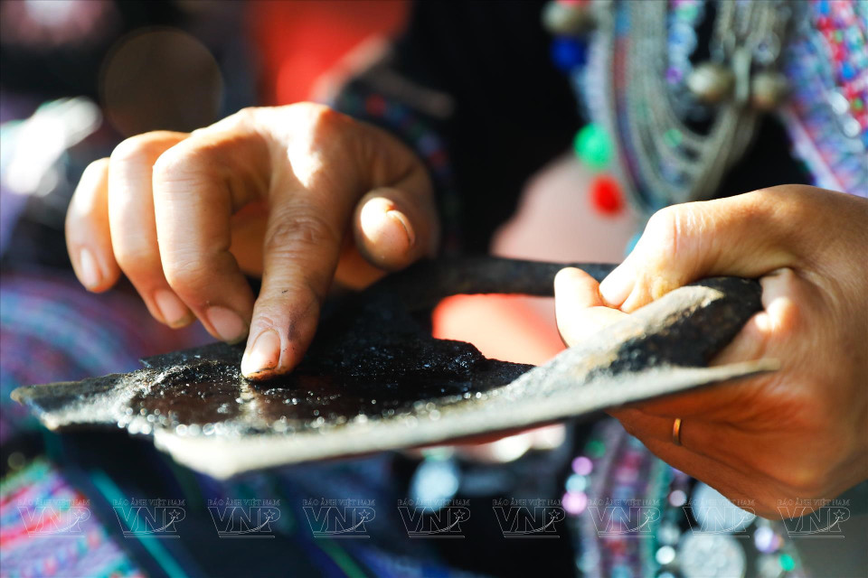 Locals rub the black substance in a cast iron plate. (Photo: VNP)