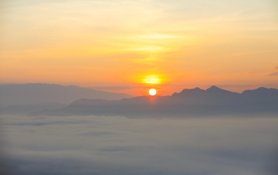 Admiring the sunrise on Tang Quai pass. (Photo: VNA)