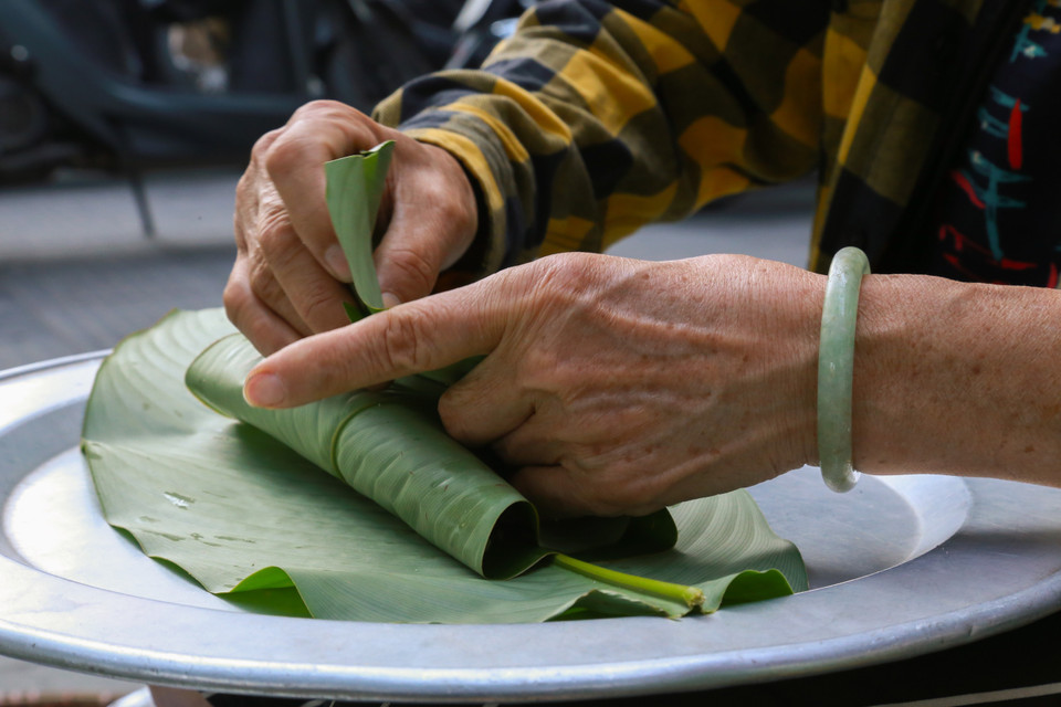 Cốm is carefully wrapped in lotus leaves and tied with green rice straw before it reaches customers. (Photo: Quynh Anh/VNA)