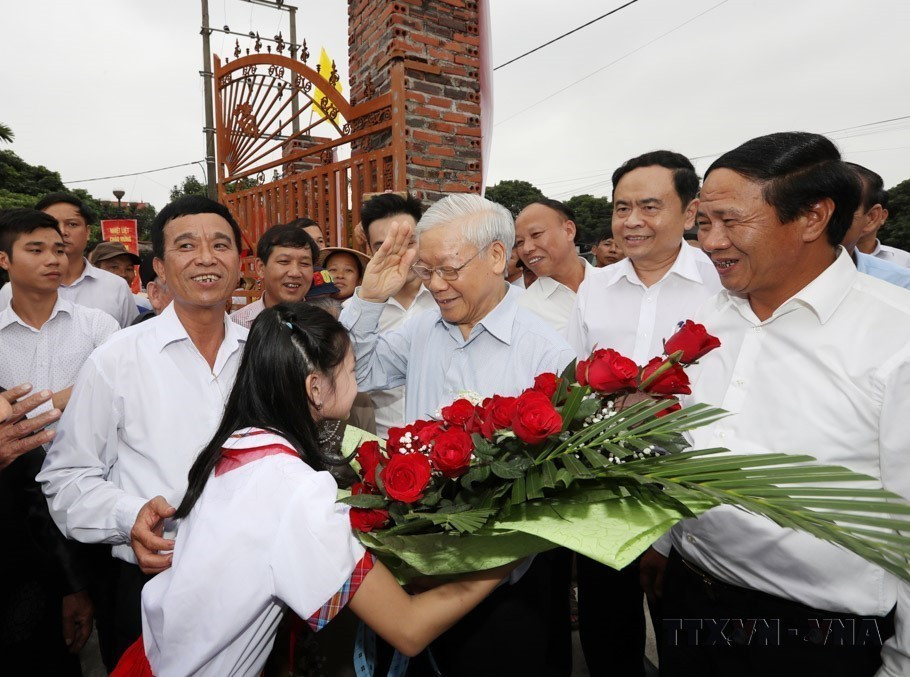 Children from Thuong Dien hamlet, Vinh Quang commune, Hai Phong, present flowers to Party General Secretary Nguyen Phu Trong at the Great National Unity Day festival in the city on November 15, 2017. (Photo: VNA)