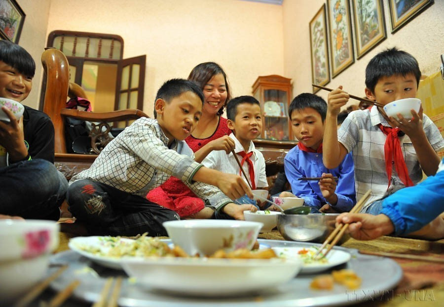 The joy of teacher Nguyen Thi Hanh Nguyen as she watches her students enjoy hearty lunches. With her care and dedication, she has been cooking free meals for over 30 students every day for six consecutive years. Her students affectionately call her “Mother Nguyen.” (Photo: VNA)