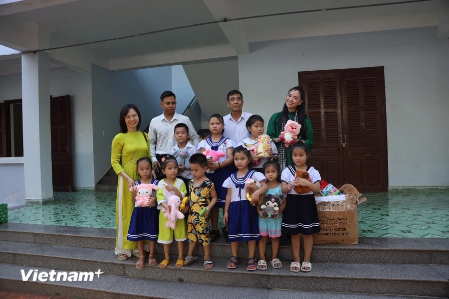 The members of the working group and the children on Truong Sa island pose for a group photo. (Photo: Vietnam+)