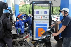 Motorcyclists have their vehicles refilled at a Petrolimex gas station. (Photo: VNA)