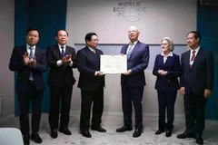 Prime Minister Pham Minh Chinh presents the honorary doctorate to Professor Klaus Schwab, Founder and Executive Chairman of the World Economic Forum. (Photo: VNA)