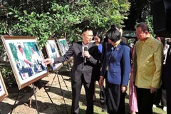 Pham Anh Tuan, Director General of the Authority of Foreign Information Service under the Ministry of Information and Communications (left) and visitors at the Bangkok exhibition featuring Vietnam’s culture, people, and landscapes. (Photo: VNA)