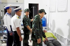 Doctors from Naval Region 4 Command provide emergency medical care to a fisherman who fell ill while working at sea. (Photo: VNA)