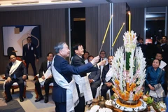Party General Secretary To Lam (right) and Lao Party General Secretary and President Thongloun Sisoulith take part in Laos’ traditional wrist-tying ceremony on February 5. (Photo: VNA)