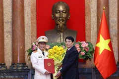 State President Luong Cuong hands over a decision on promoting Le Quoc Hung, member of the Party Central Committee and Deputy Minister of Public Security, from the rank of Lieutenant General to Senior Lieutenant General. (Phto: VNA)