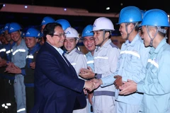 Prime Minister Pham Minh Chinh and workers at the Hoa Phat Dung Quat Iron and Steel Production Complex in Quang Ngai province. (Photo: VNA)